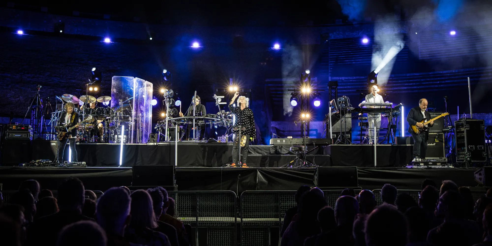 I Marillion sul palco dell'Anfiteatro degli Scavi di Pompei, con il pubblico in primo piano